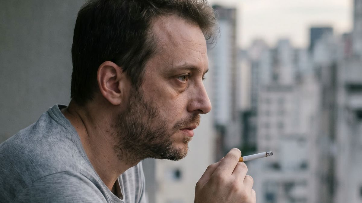 Homem sentado sozinho em uma varanda no fim do dia